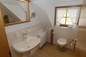 a white bathroom with a sink and a toilet at Trenklehof in Simonswald +55 photos