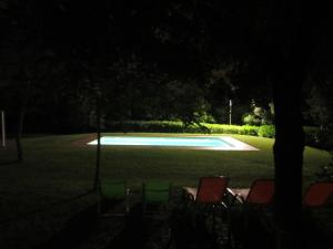 a group of chairs and a swimming pool at night at Apartament Can Pujadas in Regencós