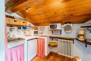 a kitchen with white appliances and wooden ceilings at El Colono El uncar in Castrejón de la Peña