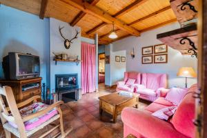 a living room with pink furniture and a fireplace at El Colono El uncar in Castrejón de la Peña