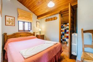 a bedroom with a bed and a wooden ceiling at El Colono El uncar in Castrejón de la Peña