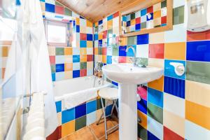 a colorful bathroom with a sink and a tub at El Colono El uncar in Castrejón de la Peña +16 photos