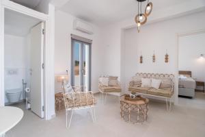 a white room with a bed and a couch and chairs at Villa Anastasio in Kampos Paros