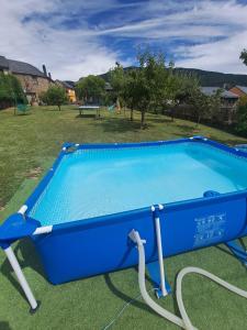 a blue swimming pool with a hose in a yard at Casa Rural Abuelo Jose in Robledo de las Traviesas