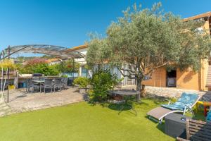 a backyard with a tree and a table and chairs at Les Cerisiers in Apt