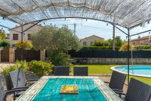 a patio with a table and chairs and a swimming pool at Les Cerisiers in Apt