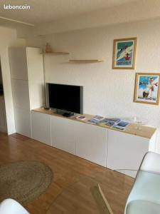 a living room with a flat screen tv and a counter at Résidence l'olympia in Montgenèvre