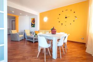 a dining room with a table and a clock on the wall at Sole e Girasoli in Molfetta