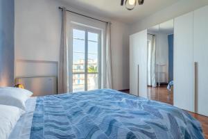 a bedroom with a blue and white bed with a window at Sole e Girasoli in Molfetta