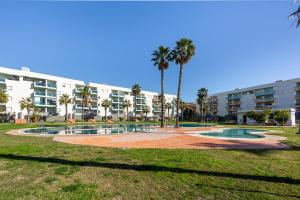 a park with palm trees and a large building at Rincon de Almerimar Palm Beach Golf in Almerimar
