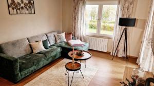 a living room with a green couch and a window at Franz Josefs Wald-Chalets in Untergriesbach