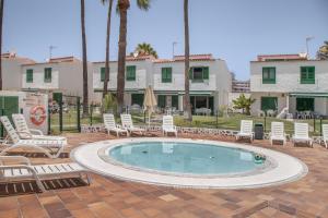 a swimming pool with lounge chairs and a building at Bungalow El Caserío De Merengue in San Bartolomé