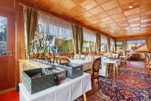 a hotel room with tables and chairs and a dining room at Hotel Bären - drei Sterne in Bernau im Schwarzwald