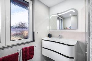 a bathroom with a white sink and a mirror at Schorsch's Ferienhaus in Winzeln +37 photos