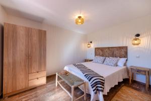 a bedroom with a bed and a wooden cabinet at Alte Com Amor in Alte