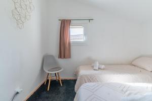 a bedroom with two beds and a chair and a window at Charming 2 bedroom House With Pool in Eyguières +14 photos