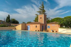 a church and a swimming pool with a tower at Charming 2 bedroom House With Pool in Eyguières