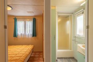 a small bedroom with a bed and a window at Mobilhome Mh 212 in La Tremblade