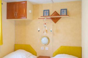 a bedroom with a bed and a mirror at Mobilhome Mh 212 in La Tremblade +13 photos