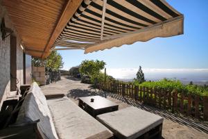 a patio with a bench and a table with a view at El cazador 2 in Granadilla de Abona