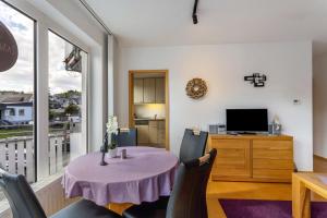 a dining room with a table and chairs and a television at Fewo Willingenliebe Meinecardplus in Willingen