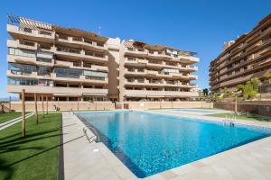 a swimming pool in front of a building at Luxury flat beach ressort sea view in Arenales del Sol