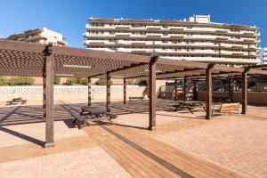 a pavilion with benches and a building in the background at Luxury flat beach ressort sea view in Arenales del Sol