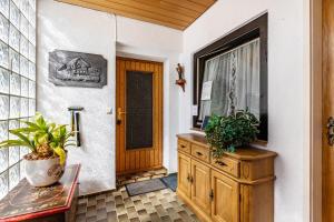 aoyer with a wooden door and a cabinet with plants at Ferienwohnung Regina in Furtwangen