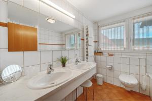 a bathroom with two sinks and a toilet at Pension Deutscher Hof in Oberbiederbach +106 photos