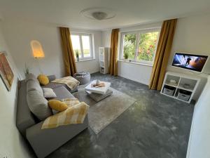 a living room with a couch and a tv at Ferienwohnung Karbachtal in Wangen im Allgäu