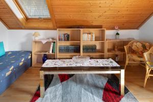 a room with a table and a bed and a book shelf at Apartmenthaus Fister in Schluchsee