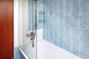 a bathroom with a shower with blue tiles at Apartmenthaus Fister in Schluchsee +21 photos