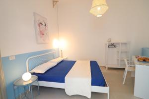 a blue and white bedroom with a bed and a table at Casa vacanze Aura a Otranto in Otranto