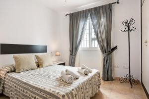 a white bedroom with a large bed with pillows on it at Vejer 1 - Andalmar in Vejer de la Frontera