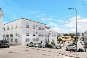 a white building with cars parked in front of it at Vejer 1 - Andalmar in Vejer de la Frontera