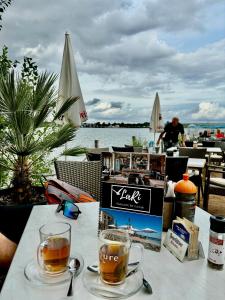 a table with two glasses of tea and a book at Ferienwohnungen Neuseenland in Rötha
