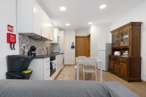 a kitchen with a table and a kitchen with white cabinets at Nuria House in Praia da Vitória