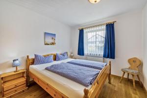 a bedroom with a bed and a window with blue curtains at Fewo Brünnstein - Nr 5 Pool, Sauna in Oberaudorf