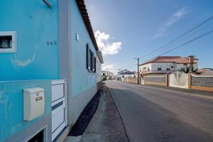 an empty street next to a blue building at Nuria House in Praia da Vitória