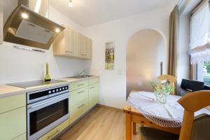 a kitchen with a stove and a table with a chair at Thum in Daisendorf +16 photos