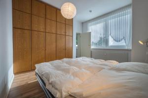 a large white bed in a room with a wall at Braunlageblick in Braunlage