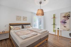 a bedroom with a bed and a pendant light at Wohlfühlhaus in Freiamt