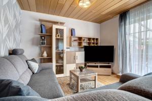 a living room with a couch and a television at Ferienwohnung K Schröder in Sundhagen-Niederhof