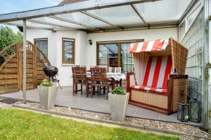 a patio with a table and chairs and a grill at Ferienwohnung K Schröder in Sundhagen-Niederhof