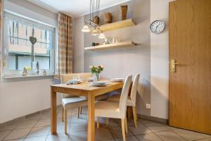 a dining room with a wooden table and chairs at Ferienwohnung K Schröder in Sundhagen-Niederhof +16 photos