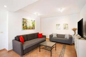 a living room with a couch and a tv at Casa Los Caideros in Los Caideros