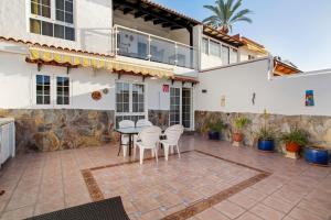 a patio with a table and chairs in front of a house at Casa Los Caideros in Los Caideros