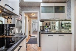 a kitchen with white cabinets and a sink at Ferienwohnung Dahmlos in Kremperheide