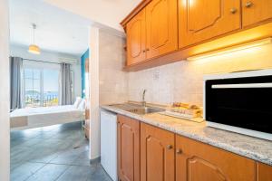a kitchen with a sink and a microwave at Spyridoula Studio 3 in Paleokastritsa