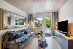 a living room with a couch and a tv at Ferienwohnung Dahmlos in Kremperheide